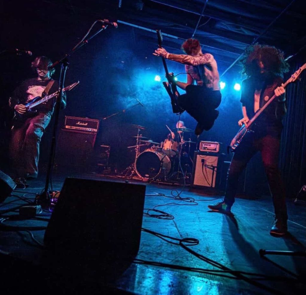 Tucson Band Spotlight: Znora 6 Znora performing live on stage with guitarist jumping during high-energy Tucson concert