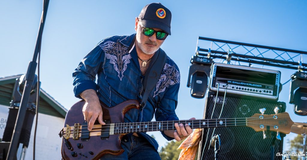 Mark Ryan of Legion of Mario playing bass guitar during an outdoor live performance in Tucson, Arizona. Photo courtesy of Chris Bachler.