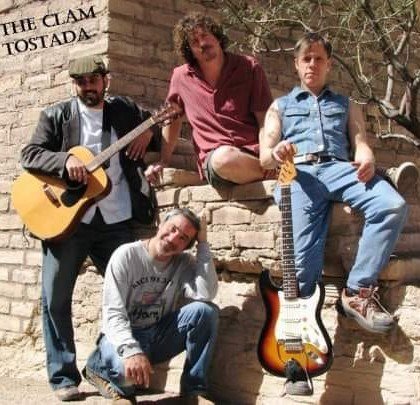 Vintage photo of Mark Ryan with The Clam Tostada band members posing outdoors with guitars against a stone wall in Tucson, Arizona.
