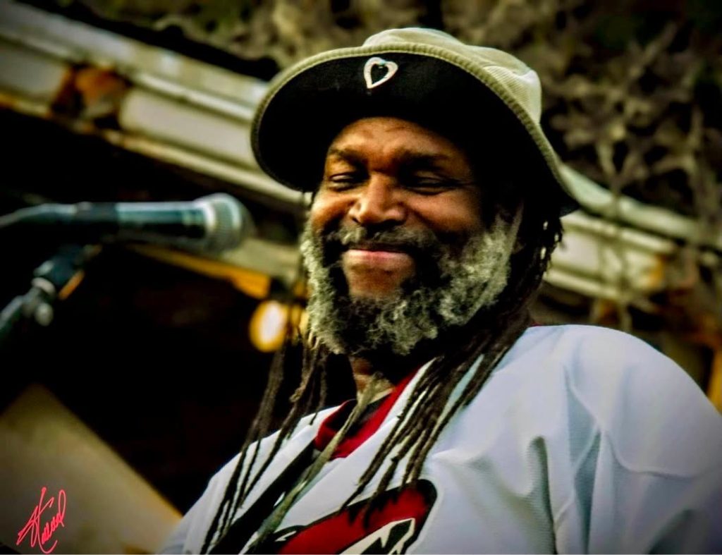 Tucson Musician Spotlight: Amochip Dabney 25 Amochip Dabney smiling on stage, photo by John Holland.